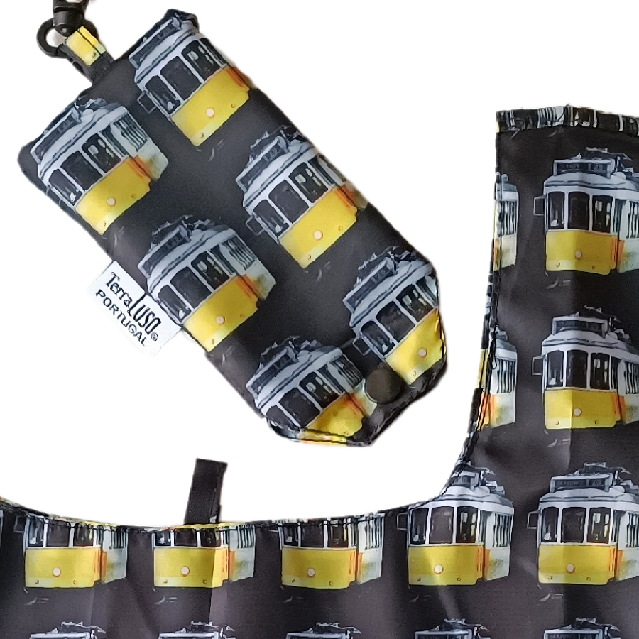 A close-up of fabric and a pouch with a yellow vintage tram pattern. The "Tram" Eco Shopper by Terra Lusa is ideal as a Lisbon tram shopping bag and features a tag reading Terra Lusa Portugal.
