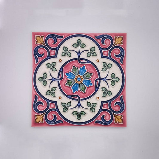 The Estoril Hand Painted Tile by Tejo Shop features a symmetrical floral motif in blue, green, yellow, and orange on a white and pink base—an elegant choice to enhance any decor.