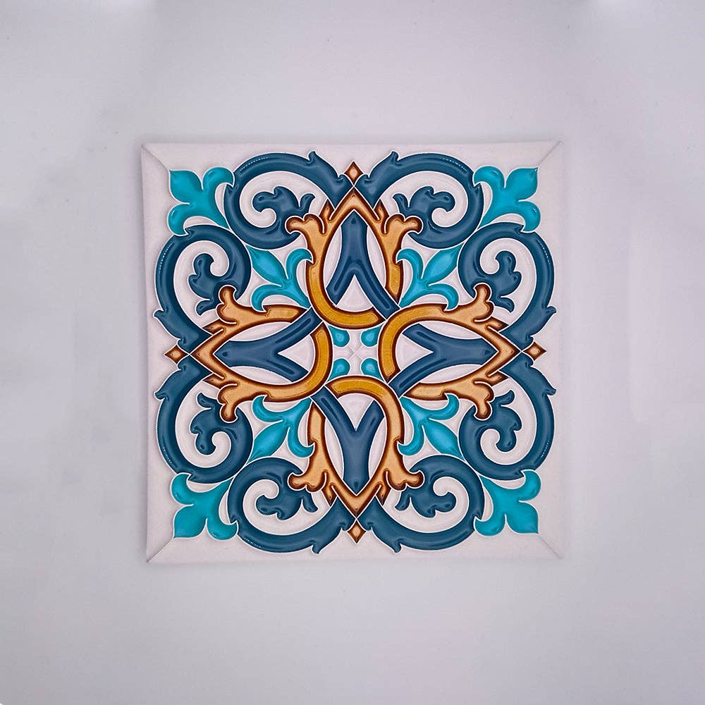 Tejo Shop’s Hand-Painted Tiles For Walls feature intricate, symmetrical Portuguese-inspired designs in blue, teal, and gold with floral and swirling motifs on a white background.