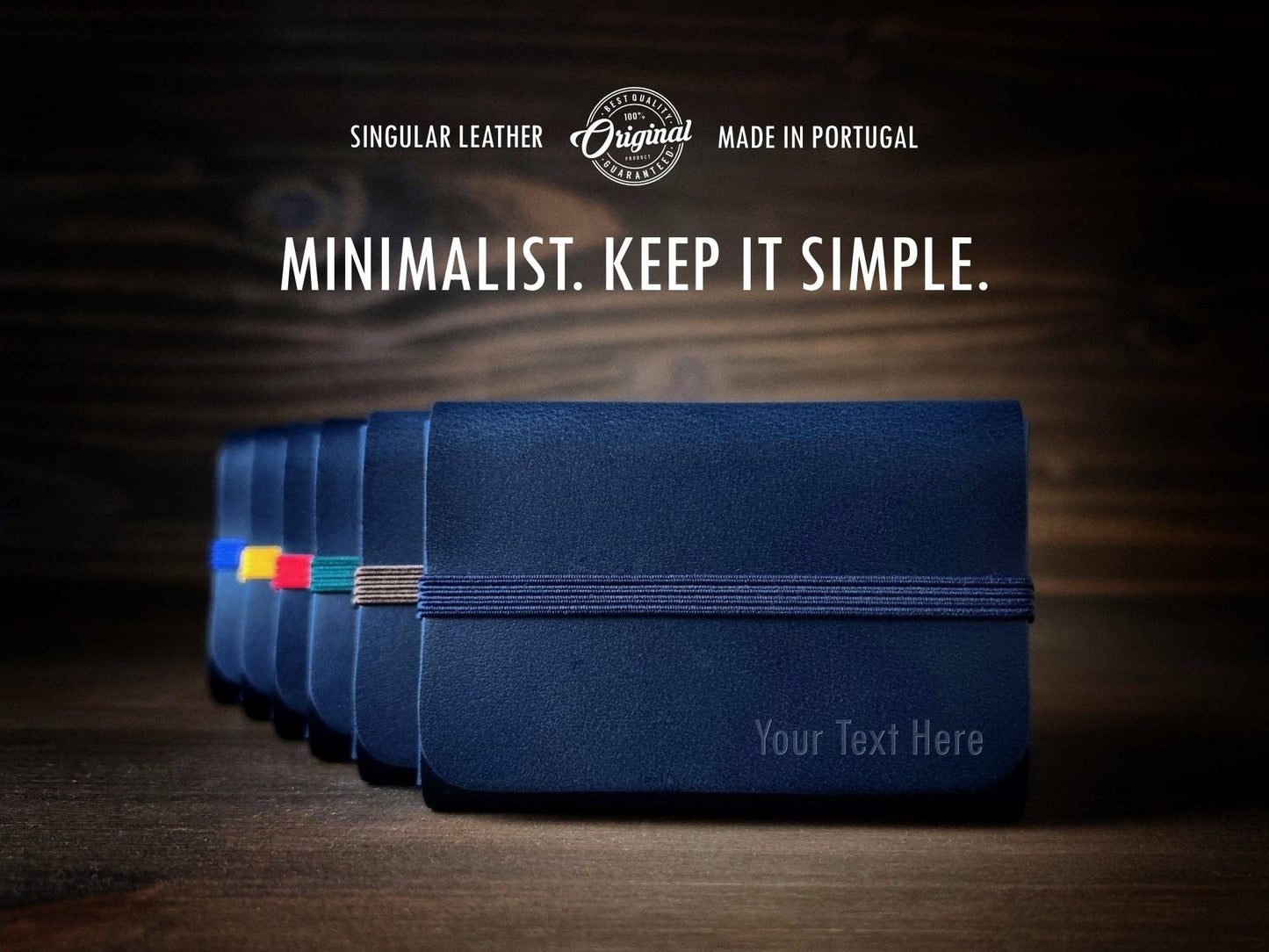 A row of Singular Leather Marine Blue wallets, each with a unique elastic band, rests on wood. The text above: Minimalist. Keep it simple—with RFID protection.