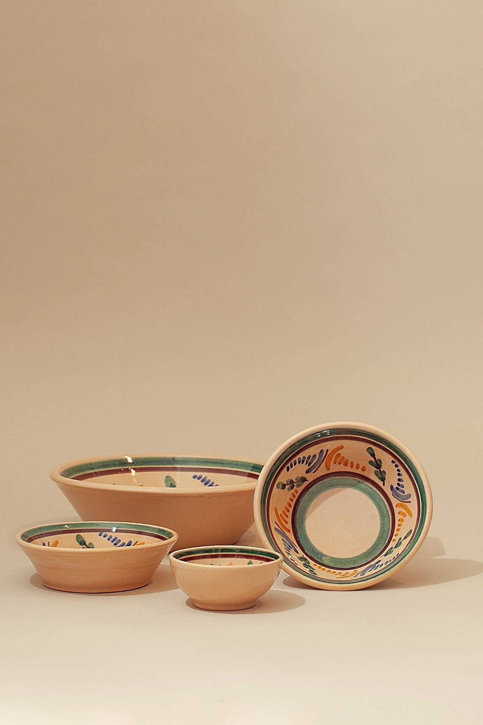 Four Eturel Madrid Medina Printed Ceramic Bowls of different sizes are displayed on a neutral surface, each featuring intricate green, yellow, blue, and orange patterns inspired by Andalusian ceramic traditions.
