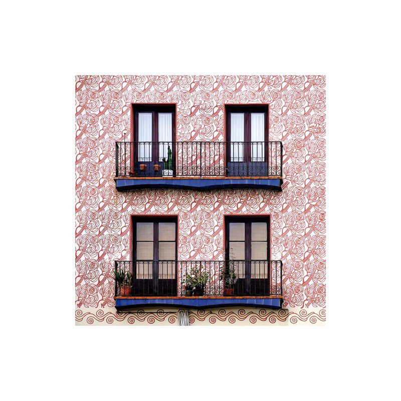 A building facade with two balconies, each showcasing potted plants in Barceloning’s Born Roses Cotton Flower Vases, plus four glass doors. The wall features a red and white swirl pattern inspired by Barcelona modernist design.