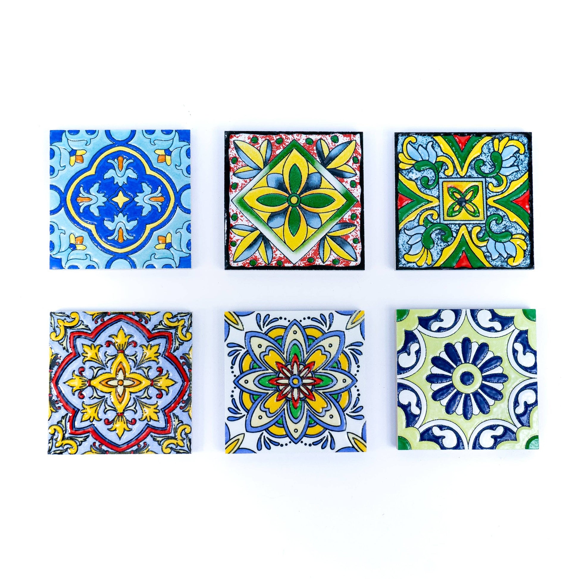 The Tile-Inspired Ceramic & Cork Coasters - Set of 6 by Meninas Bonitas Cork features six coasters in two rows of three, each displaying intricate, symmetrical patterns in vibrant blue, yellow, red, and green hues.