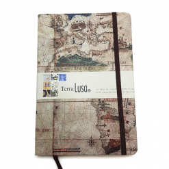 A Terra Lusa notebook with a vintage map cover and brown elastic band features a front label and ribbon bookmark—ideal to pair with the Cantino Eco Shopper from Terra Lusa.