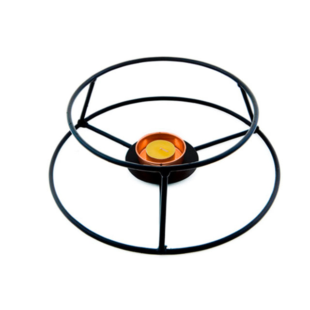 The Iberica Cataplana starter kit features a black metal stand with circular rings and three legs, inspired by Portuguese cooking, designed to hold a small orange tealight candle in the center.
