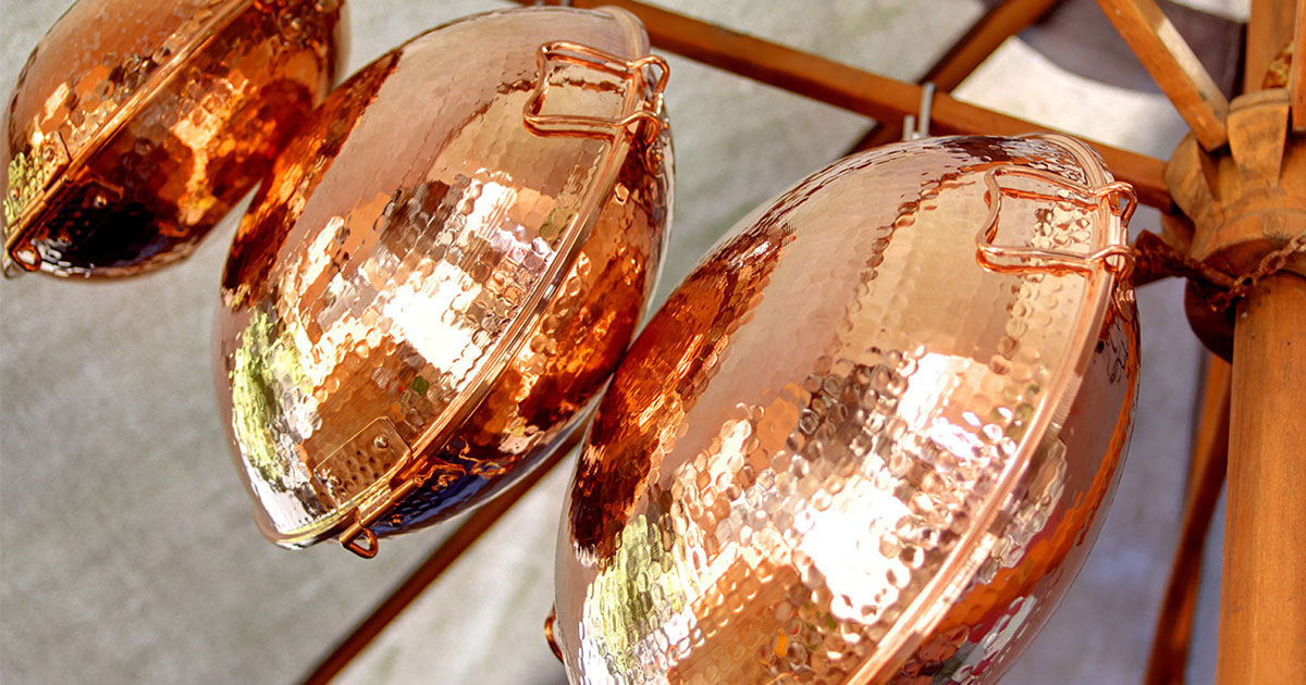 Copper Portuguese cataplana cookware with seafood stew including prawns and mussels, traditional clam shaped cooking pot