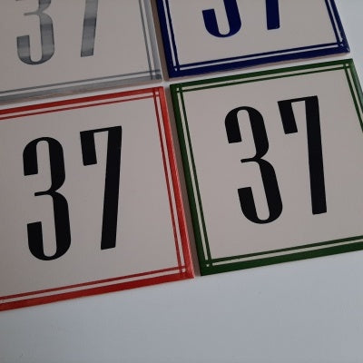 TilePassion’s Handpainted Ceramic Door Numbers – Custom Portuguese Tiles: Four number 37 tiles, each with a red, green, blue, or gray border, are arranged together on a white surface.