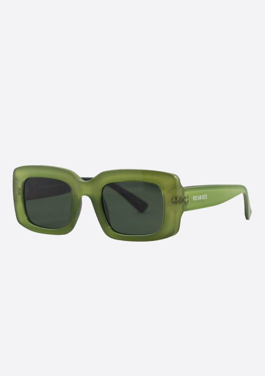 The Oceanides Sunglasses (Polarized) - Ida Crystal Green Black feature rectangular thick frames, dark lenses, and white "OCEANIDES" branding on one arm, offering a stylish minimalist look against a plain light background.