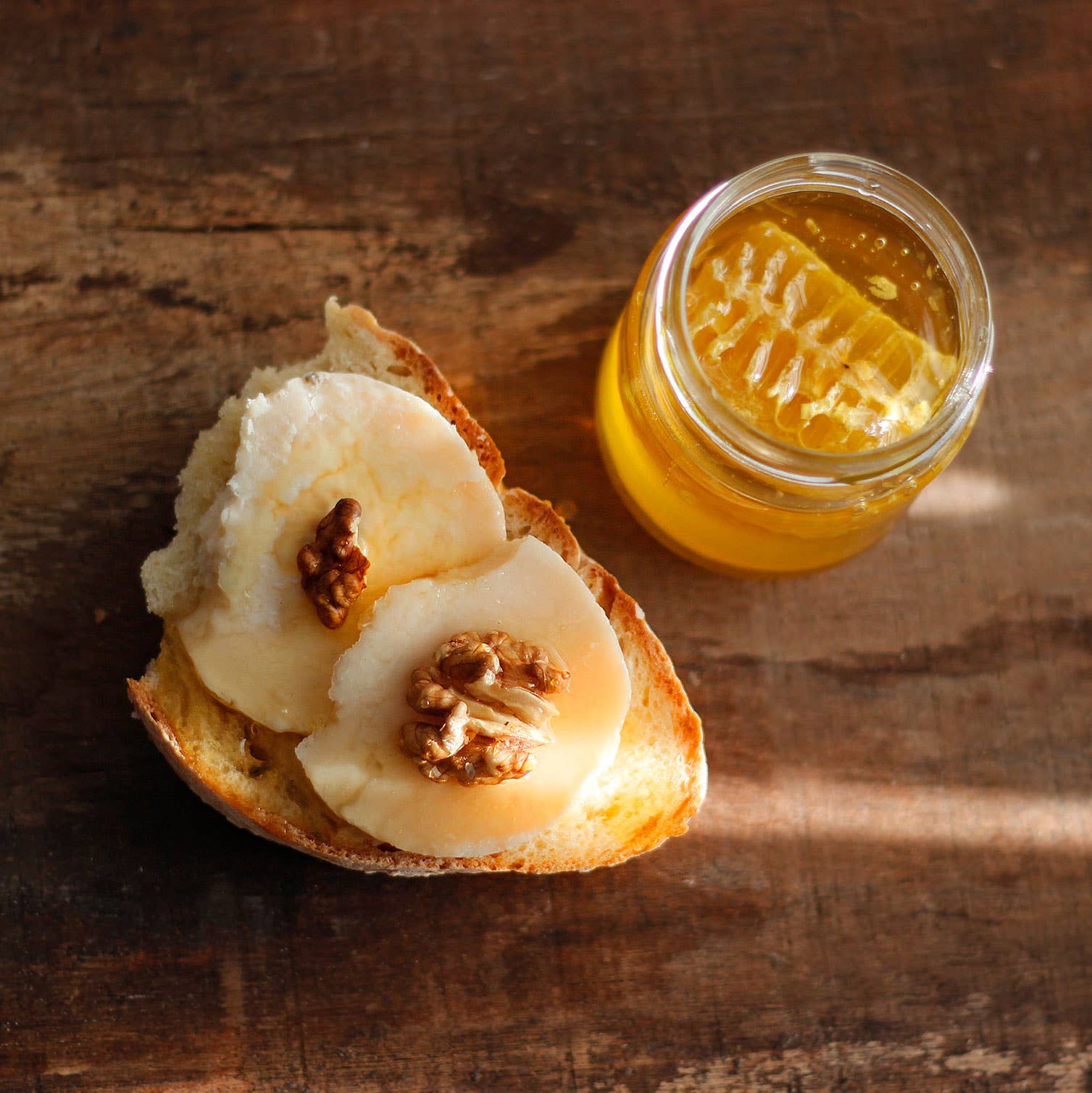 honey jar with serving of bread with cheese and walnuts