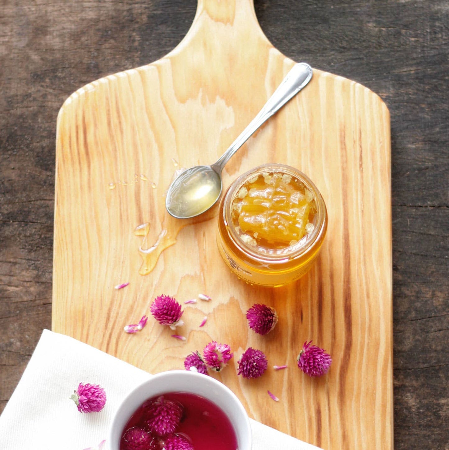 honey jar on a wooden serving board with Purple evergreen