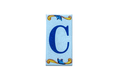 Lisa Croquets Letters – Ceramic House Letter Tile featuring a rectangular Spanish design with a blue letter C and decorative yellow and blue scrollwork borders.