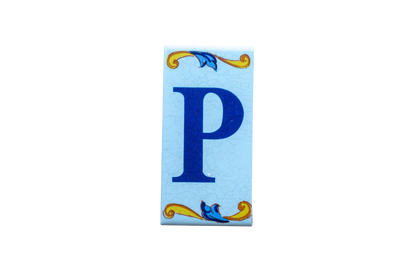 Lisa Croquets Letters – Ceramic House Letter Tile featuring a rectangular design with a blue letter P surrounded by blue and yellow scrollwork on a light blue background.