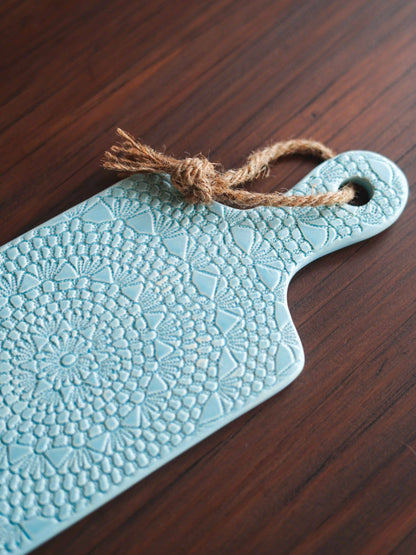 Light blue porcelain board with beautiful crochet pattern crafted
