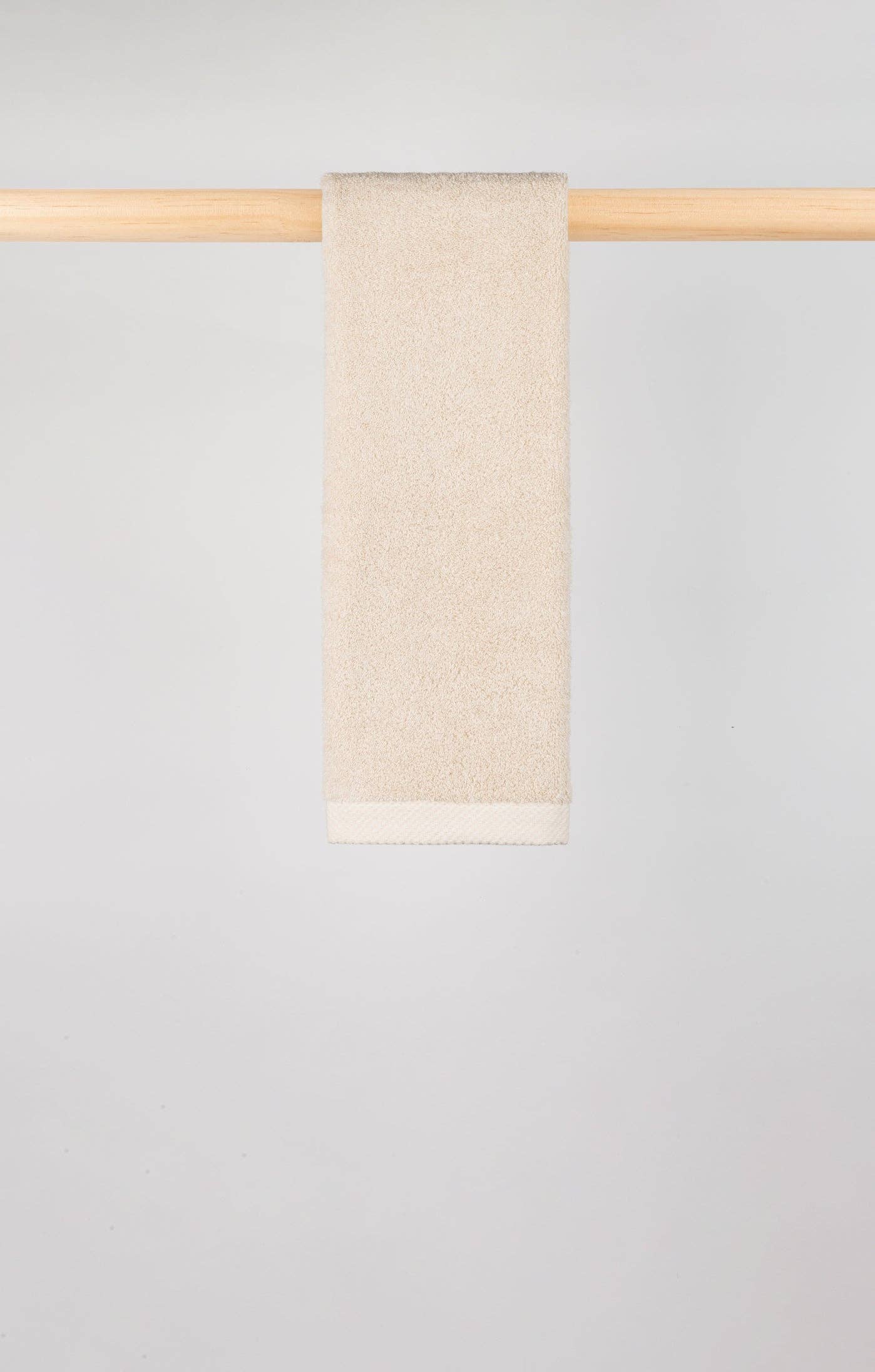 Image of Natural Torres Novas X Zero hand towel hanging on a wooden rail